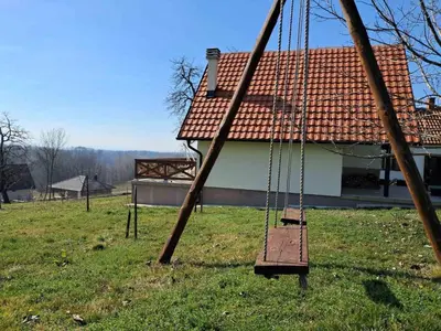 a swing in a yard in front of a house at Vikendica Živković in Lazarevac
