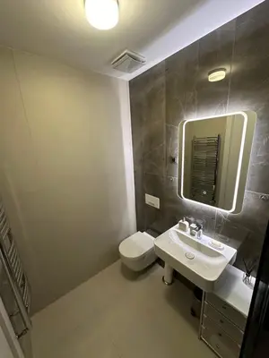 a bathroom with a toilet and a sink and a mirror at LL65 Apartments Novi Dorcol in Belgrade
