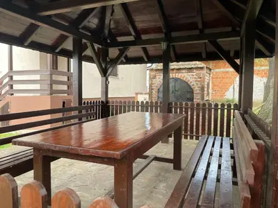 a wooden table on a patio with two benches at Vila Plavinac in Smederevo
