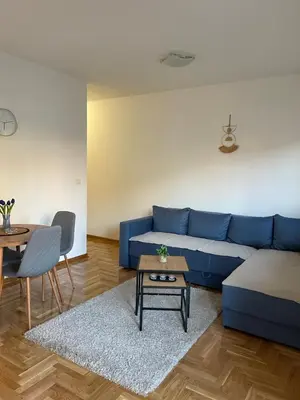 a living room with a blue couch and a table at Cvetanov trg LUX 4 in Belgrade