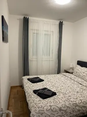a bedroom with a bed with two black towels on it at Cvetanov trg LUX 4 in Belgrade