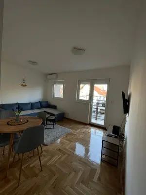 a living room with a blue couch and a table at Cvetanov trg LUX 4 in Belgrade