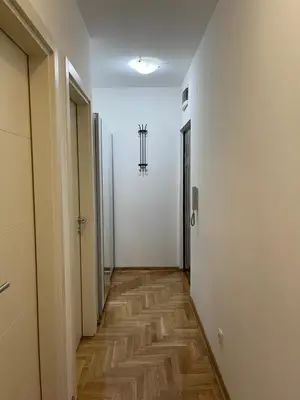 a hallway with white walls and a wooden floor at Cvetanov trg LUX 4 in Belgrade