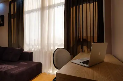 a bedroom with a laptop on a desk with a bed at Apart K Apartments in Belgrade