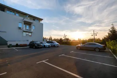 a parking lot with cars parked in front of a building at Apart K Apartments in Belgrade