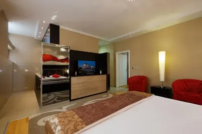 a bedroom with a bed and a flat screen tv at Apart K Apartments in Belgrade
