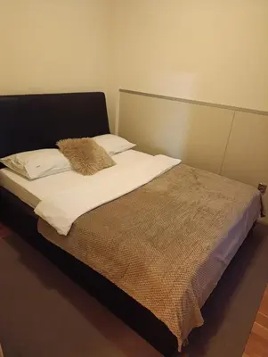 a bed with white sheets and a brown blanket at TWINS in Belgrade