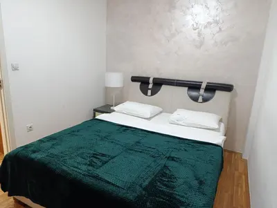 a bedroom with a bed with a green blanket at TWINS in Belgrade