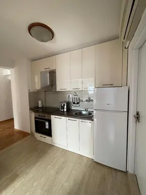 a kitchen with white cabinets and a white refrigerator at BMM LUX APARTMENT CENTAR in Belgrade