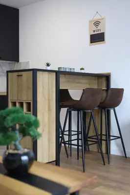 a desk with two chairs and a table with a plant at Tesla Sky Apartment in Ledine
