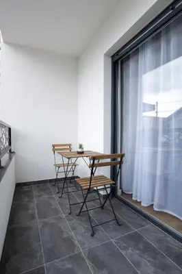 a table and chairs in a room with a window at Tesla Sky Apartment in Ledine