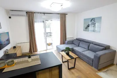 a living room with a couch and a table at Tesla Sky Apartment in Ledine