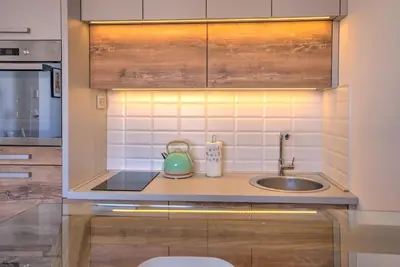 a kitchen with a sink and a green tea kettle at Belgrade Central Apartment in Belgrade