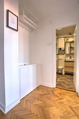 an empty room with a white wall and wooden floors at Belgrade Central Apartment in Belgrade