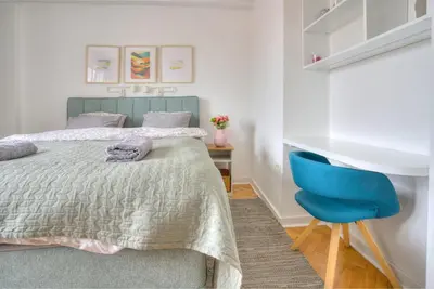 a bedroom with a bed and a blue chair at Belgrade Central Apartment in Belgrade