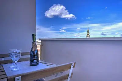 a table with a wine bottle and a glass on a balcony at Belgrade Central Apartment in Belgrade