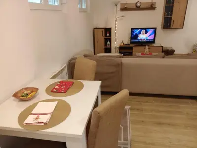 a living room with a table and chairs and a couch at Apartman DUDA Surčin in Surčin