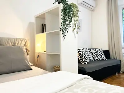 a bedroom with a bed and a chair at Fully Equipped - Cozy & Convenient City Apartment in Belgrade