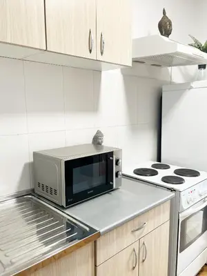 a microwave oven sitting on a counter in a kitchen at Fully Equipped - Cozy & Convenient City Apartment in Belgrade