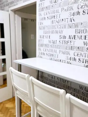 a table and two white chairs in front of a wall with graffiti at Fully Equipped - Cozy & Convenient City Apartment in Belgrade