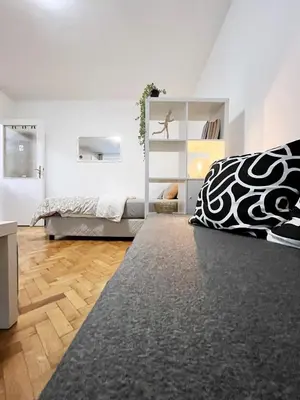 a bedroom with a bed with a black and white blanket at Fully Equipped - Cozy & Convenient City Apartment in Belgrade