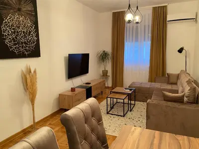 a living room with a couch and a tv at Anči apartmani in Belgrade