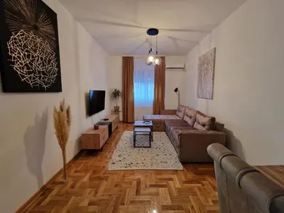 a living room with a couch and a tv at Anči apartmani in Belgrade
