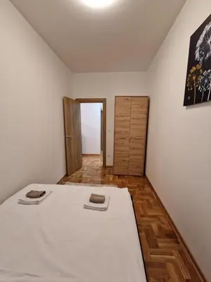 a bedroom with a bed and a wooden floor at Anči apartmani in Belgrade