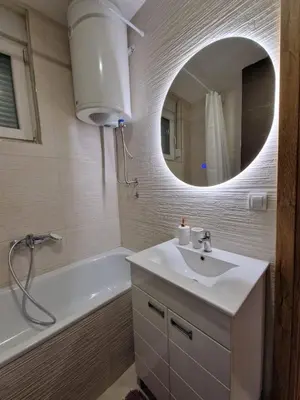a bathroom with a sink and a tub and a mirror at Anči apartmani in Belgrade