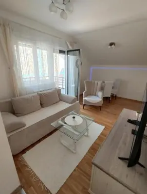 a living room with a couch and a table at DomaćIN in Ledine