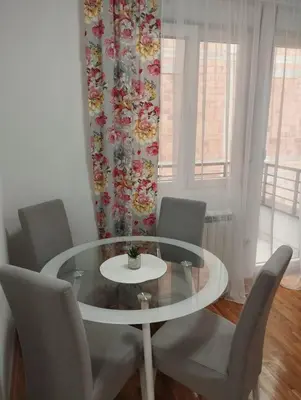 a dining room with a glass table and chairs at DomaćIN in Ledine