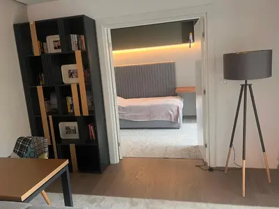a room with a bedroom with a bed and a lamp at Autokomanda Large Family Apartment in Belgrade