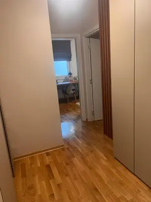 an empty room with a desk and a room with a wooden floor at Autokomanda Large Family Apartment in Belgrade