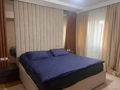 a bedroom with a large bed with blue sheets at Autokomanda Large Family Apartment in Belgrade