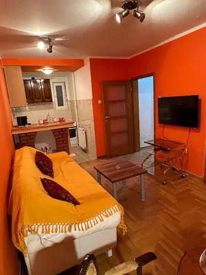 a living room with a bed and a tv in it at Urban Nest - Orange in Belgrade
