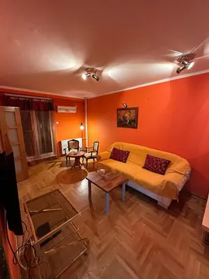 a bedroom with orange walls and a bed and a table at Urban Nest - Orange in Belgrade