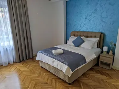 a bedroom with a bed with a blue wall at Dorcol - the Heart of Belgrade in Belgrade