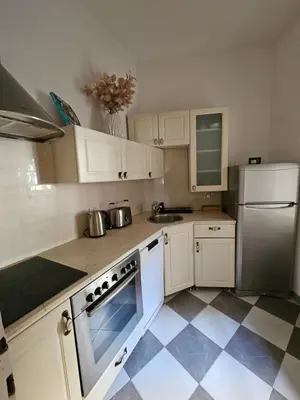 a kitchen with white cabinets and a tile floor at Dorcol - the Heart of Belgrade in Belgrade