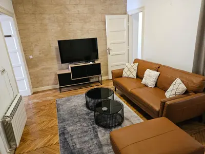 a living room with a couch and a flat screen tv at Dorcol - the Heart of Belgrade in Belgrade