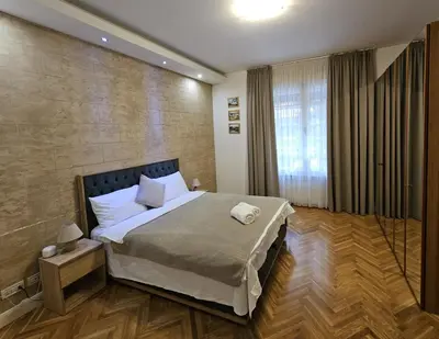 a bedroom with a bed and a large window at Dorcol - the Heart of Belgrade in Belgrade
