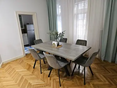 a dining room table with chairs and a wooden floor at Dorcol - the Heart of Belgrade in Belgrade