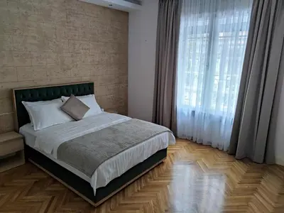 a bedroom with a bed and a large window at Dorcol - the Heart of Belgrade in Belgrade