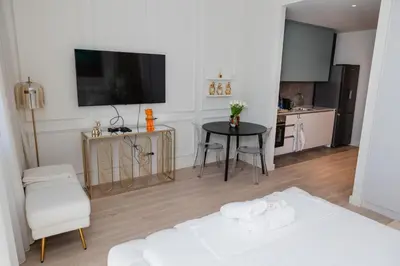 a room with a bed and a table and a kitchen at Studio Passion-Belgrade Waterfront in Belgrade