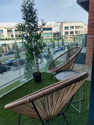 a pair of chairs and a tree on a balcony at Studio Passion-Belgrade Waterfront in Belgrade
