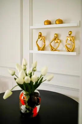 a vase of flowers on a table with gold rings at Studio Passion-Belgrade Waterfront in Belgrade