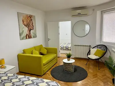a living room with a yellow couch and a mirror at Cozy Apartment in Belgrade Downtown in Belgrade