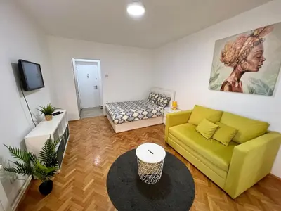 a living room with a yellow couch and a table at Cozy Apartment in Belgrade Downtown in Belgrade