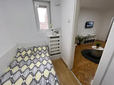 a small bedroom with a bed and a window at Cozy Apartment in Belgrade Downtown in Belgrade
