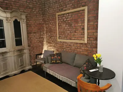 a living room with a couch and a brick wall at Cosy City Hideway in Belgrade