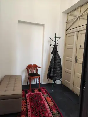 a room with a couch and a chair and a door at Cosy City Hideway in Belgrade